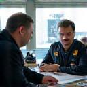 An instructor training a small group on technical equipment.